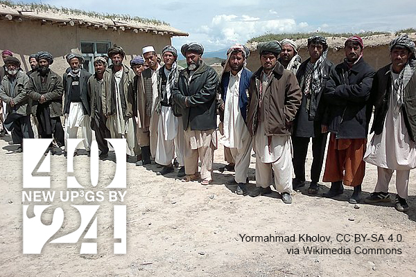 group of men wearing turbans or hats and warm jackets over their traditional clothing. Photo by Yormahmad Kholav CC BY-SA 4.0 via Wikimedia Commons