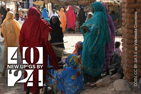 women in bright chadors in a marketplace in Darfur Sudan. COSV CC BY-SA 3.0 via Wikimedia Commons