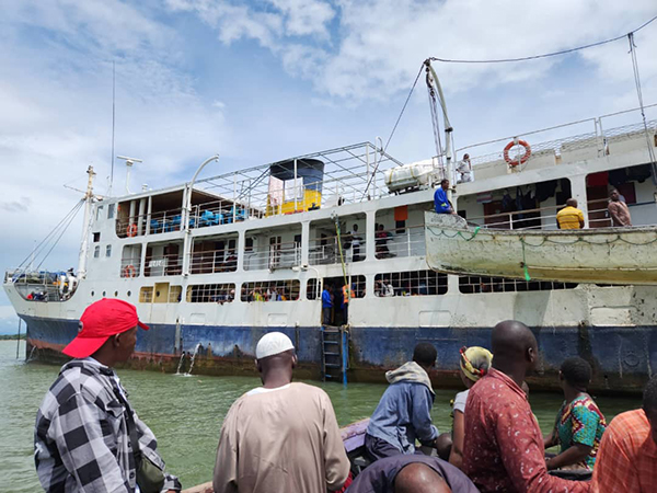 several men look at a ferry boat