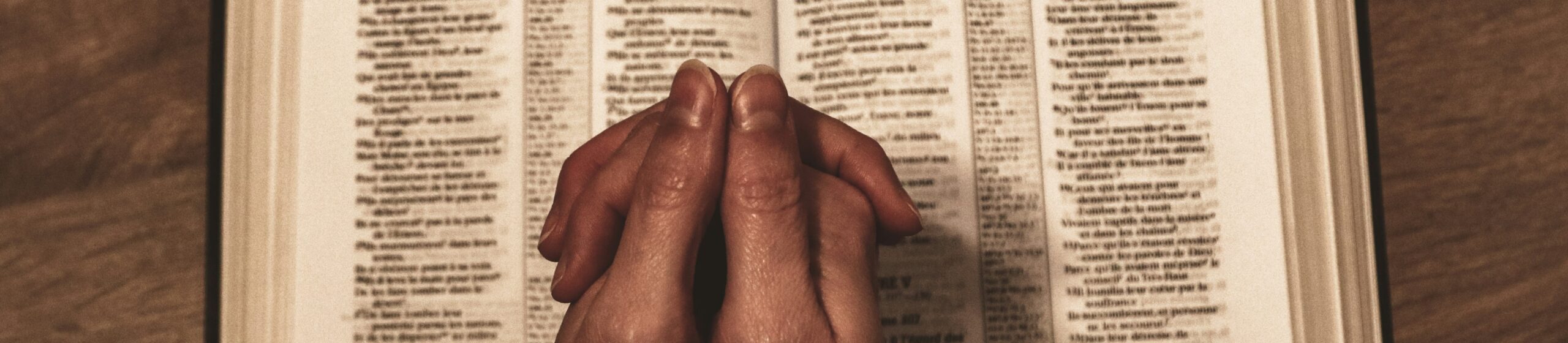 Photo of woman's hands on open Bible by Jametlene Reskp on Unsplash