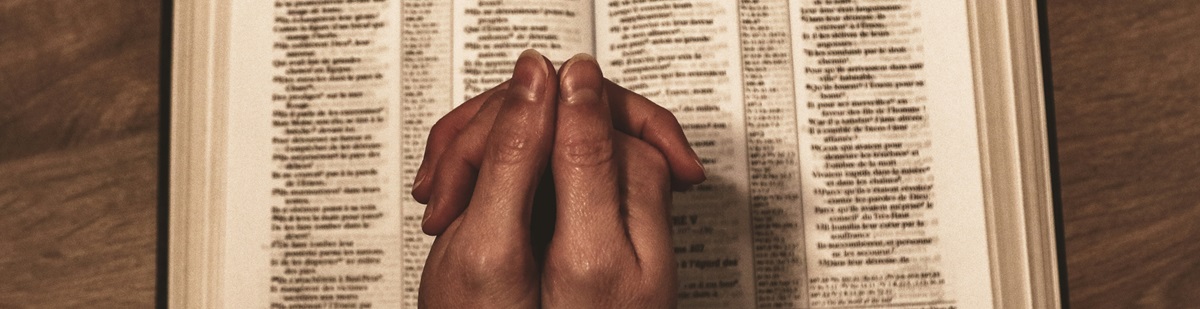 hands on a Bible. Photo by Jemtlene Reskp