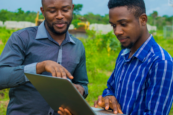 Two men in Africa using a laptop