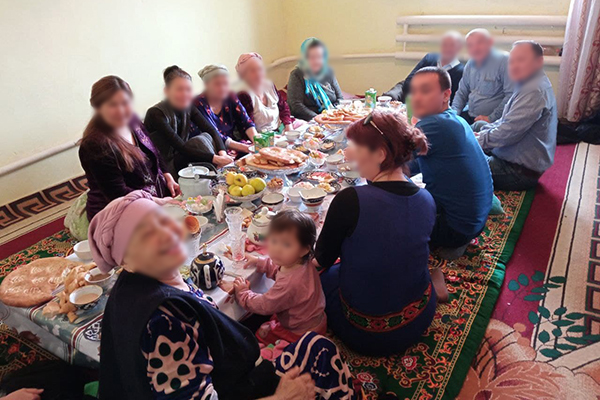 a group of men and women sitting at a table with many dishes