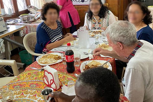 people gathered around a table sharing a mean